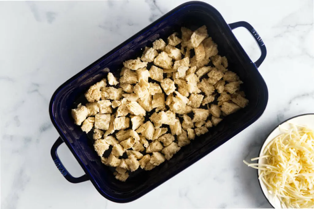 Adding bread cubes to a casserole dish.