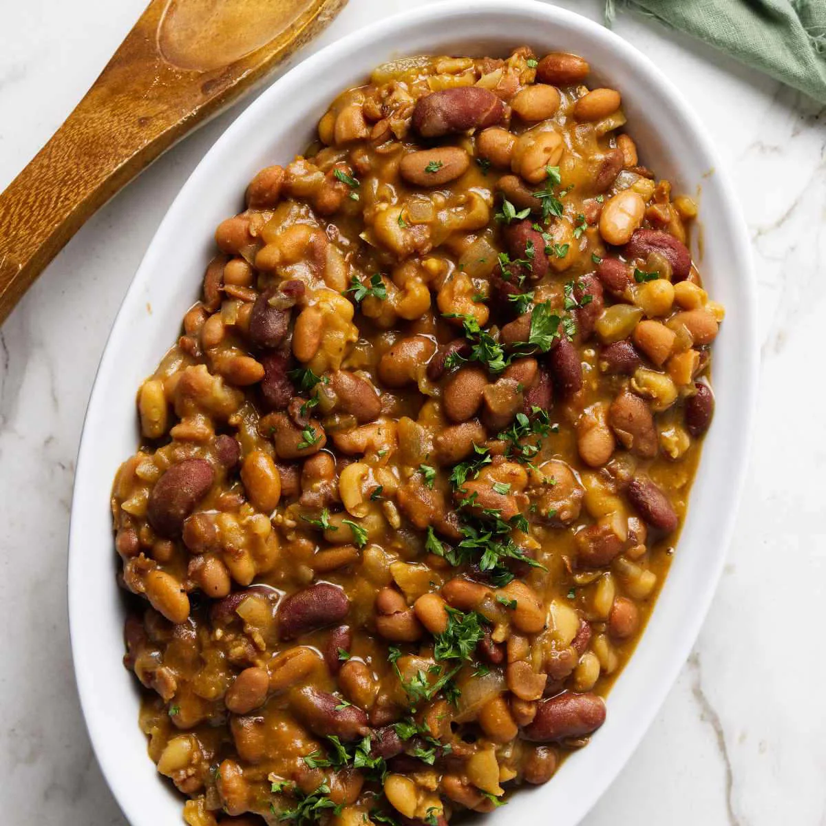 A serving dish filled with baked beans slow cooker.