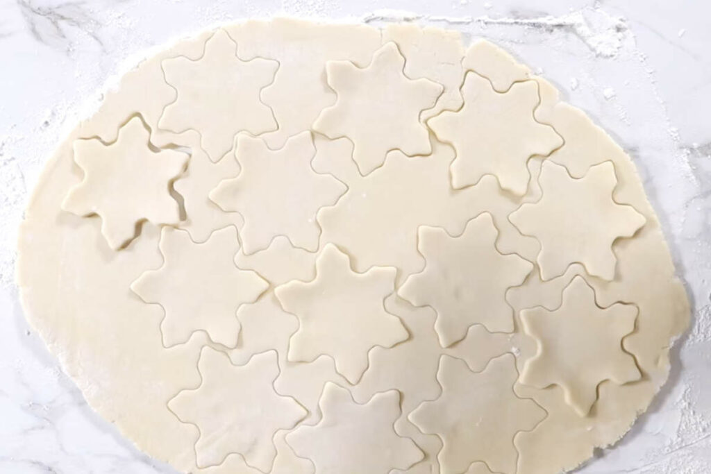 Cutting cookie shapes from rolled out sugar cookie dough.