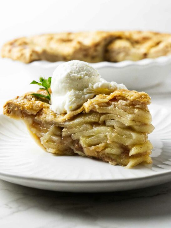 A slice of deep-dish apple pie with a scoop of ice cream.