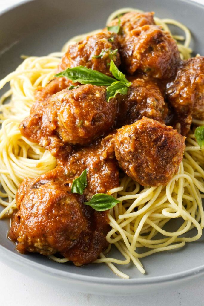 Meatballs on a plate with spaghetti noodles.