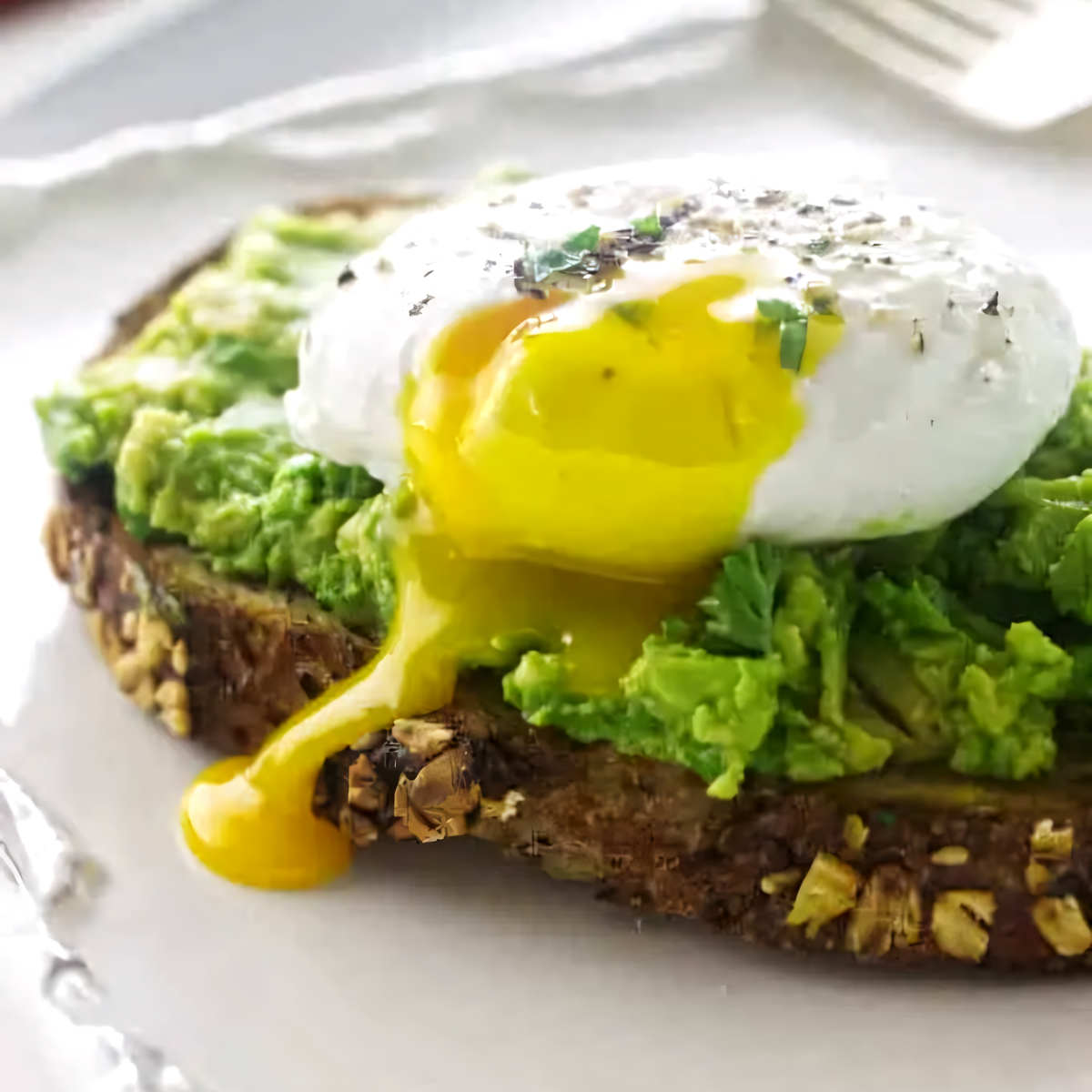 A soft poached egg on avocado toast.