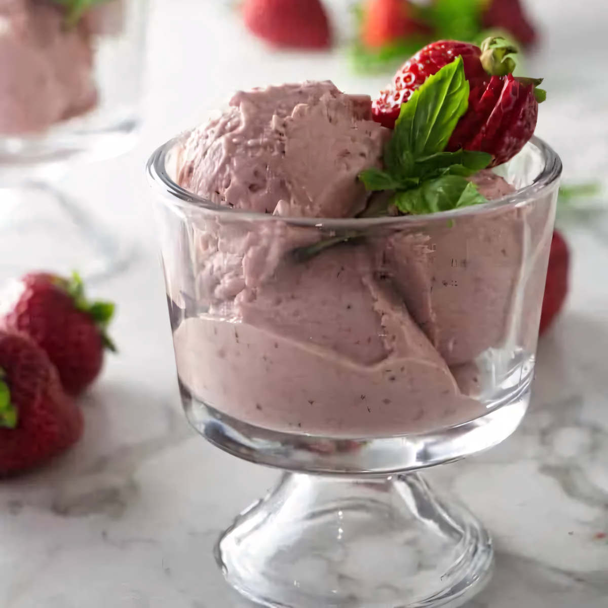 A dish of strawberry goat cheese ice cream with basil infusion.