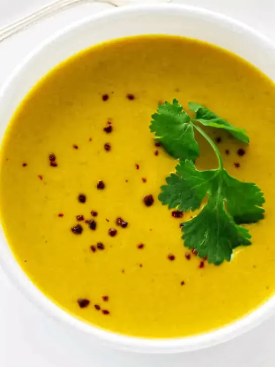 Pumpkin soup with coconut milk topped with parsley.