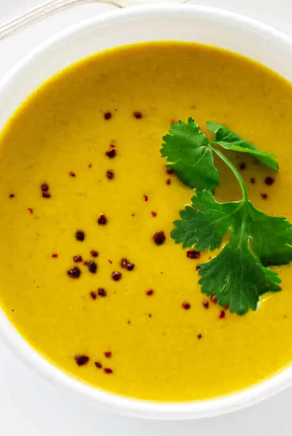 Pumpkin soup with coconut milk topped with parsley.