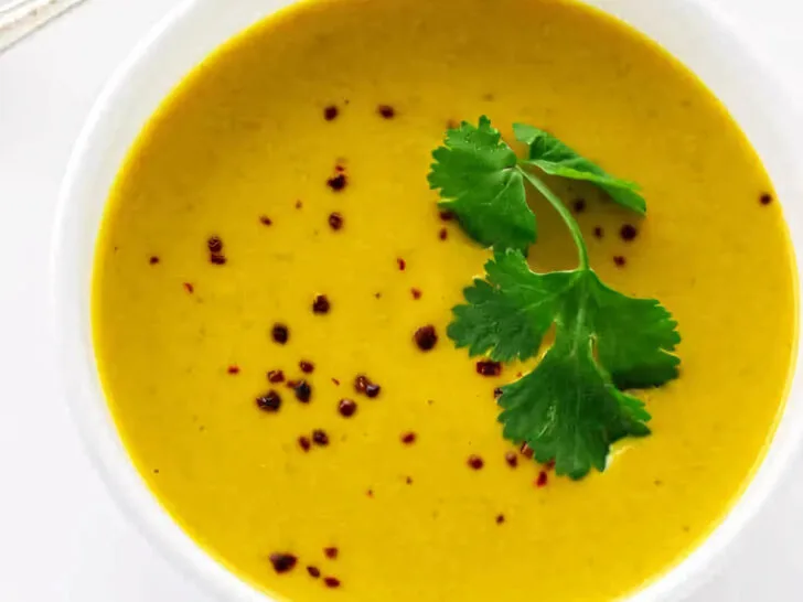 Pumpkin soup with coconut milk topped with parsley.