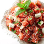 A watermelon feta salad in a serving dish with mint garnish.