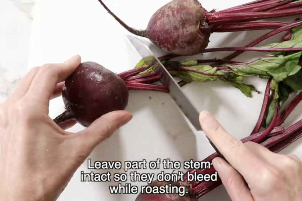 Slicing the leaves off a fresh beet.