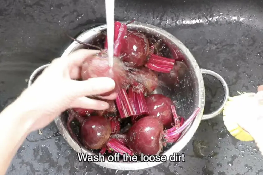 Washing beets under cold water.