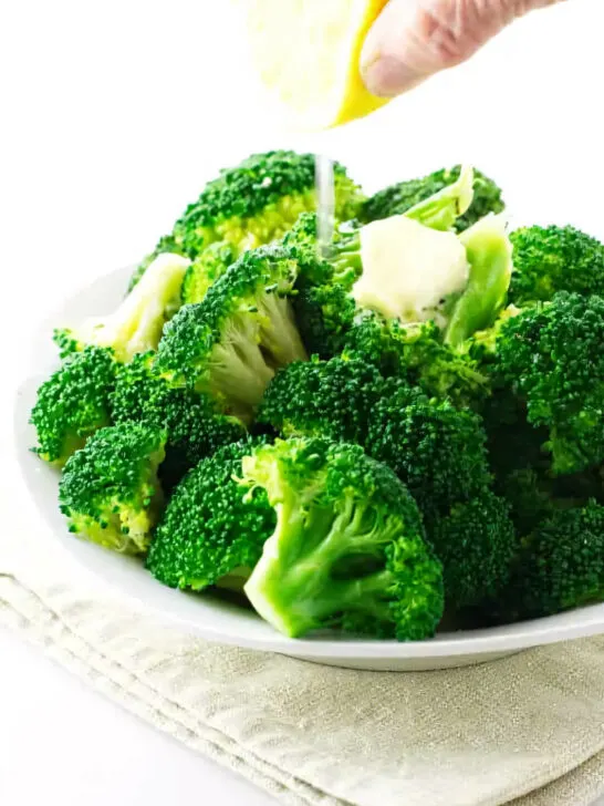 A serving of freshly steamed broccoli with a squeeze of lemon.