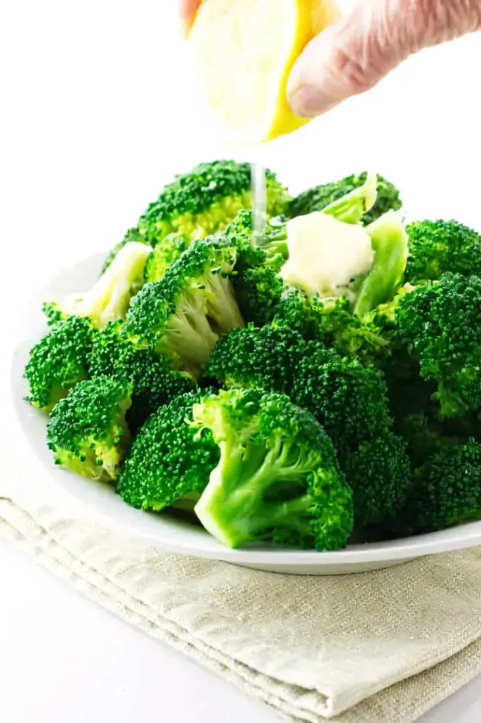 A serving of freshly steamed broccoli with a squeeze of lemon.