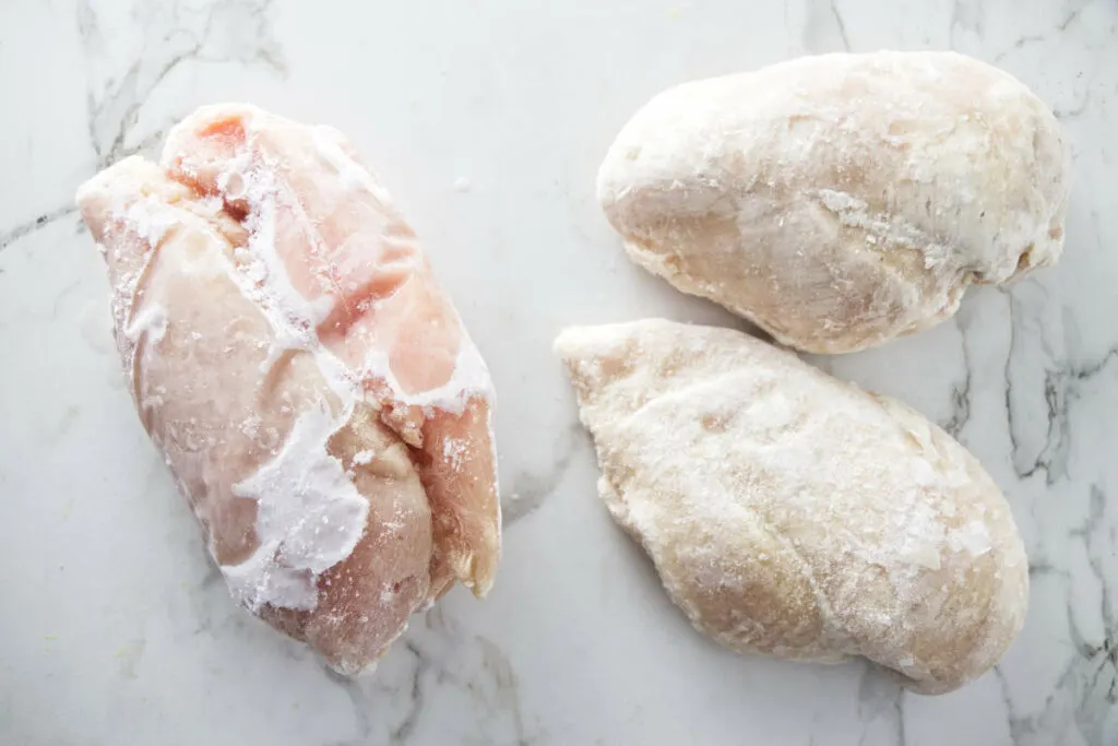 Two pieces of frozen chicken clumped together on the left and two individually frozen pieces on the right.