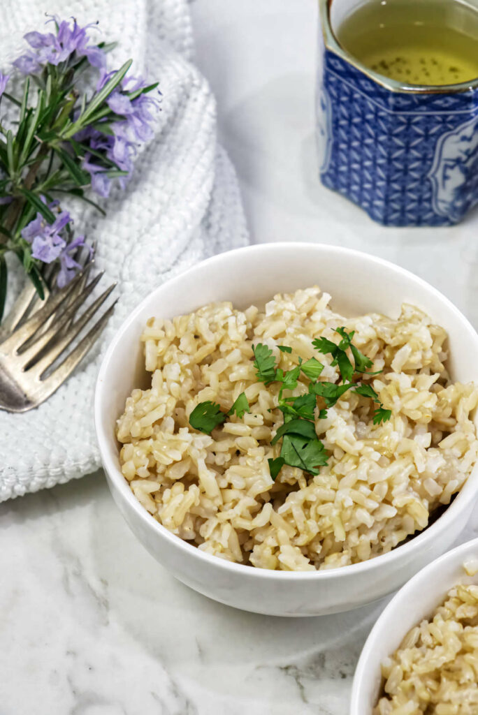 A bowl of sprouted brown rice next to a cup of tea.