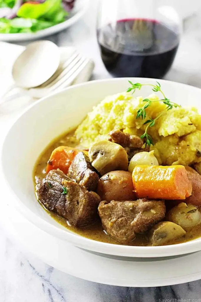 A bowl filled with lamb stew and polenta.