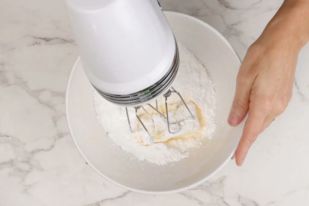 Beating the butter and sugar together for maple syrup cream cheese frosting.