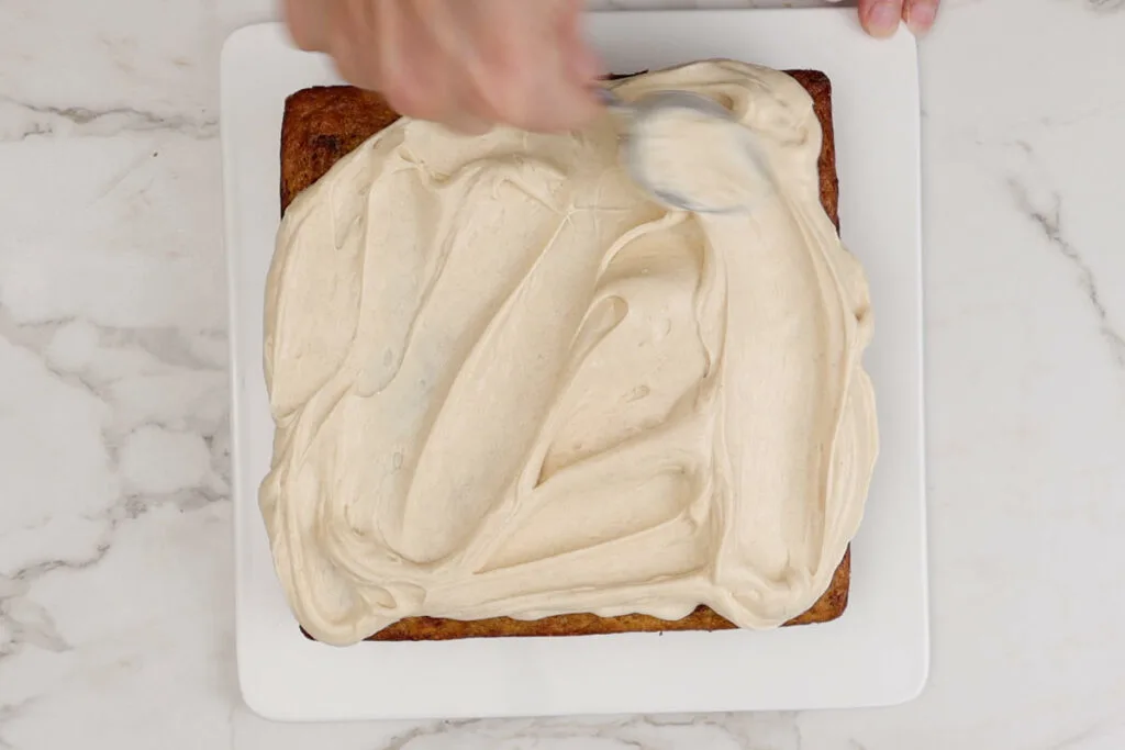 Spreading old fashioned maple frosting on a cake.