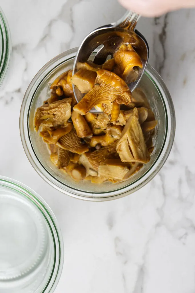 Spooning chanterelles into jars.