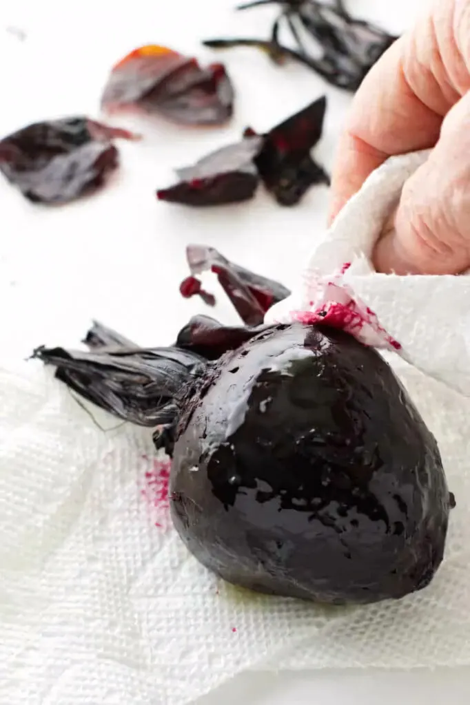 Removing the skin from a roasted beet.