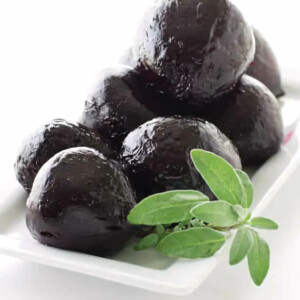 A platter of roasted beets with a garnish of sage.