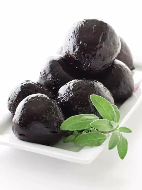 A platter of roasted beets with a garnish of sage.