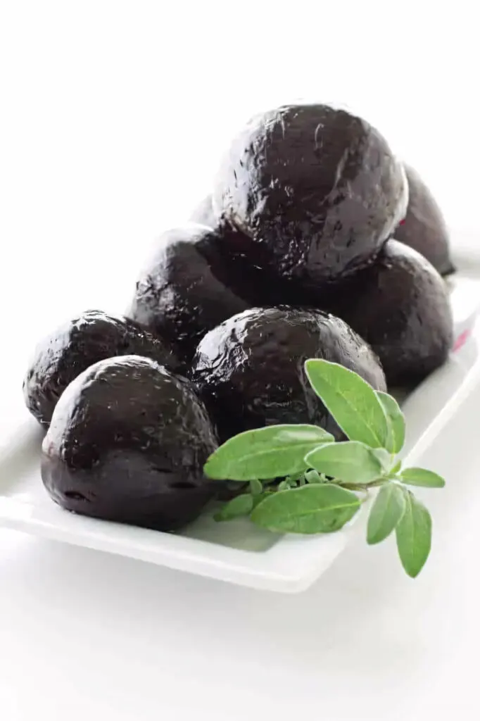 A platter of roasted beets with a garnish of sage.