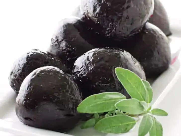 A platter of roasted beets with a garnish of sage.