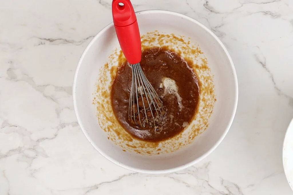 Stirring sugar and brown butter together.