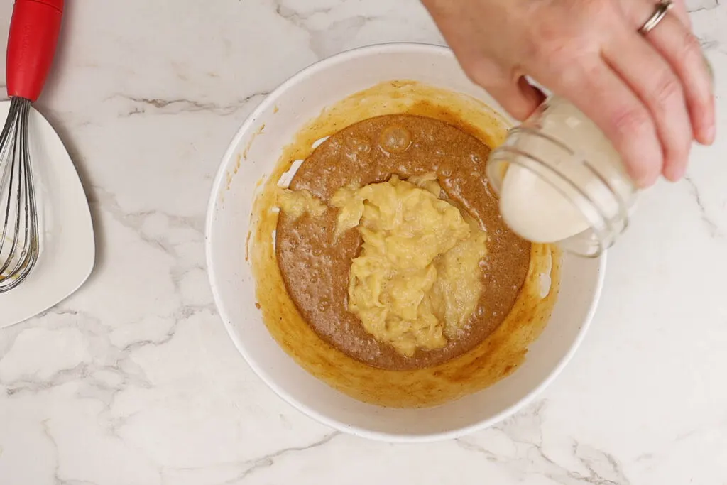 Adding bananas and sourdough discard to cake batter.