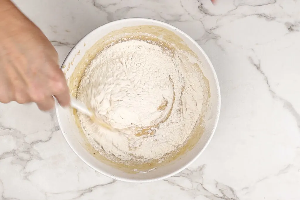 Folding flour into sourdough cake batter.