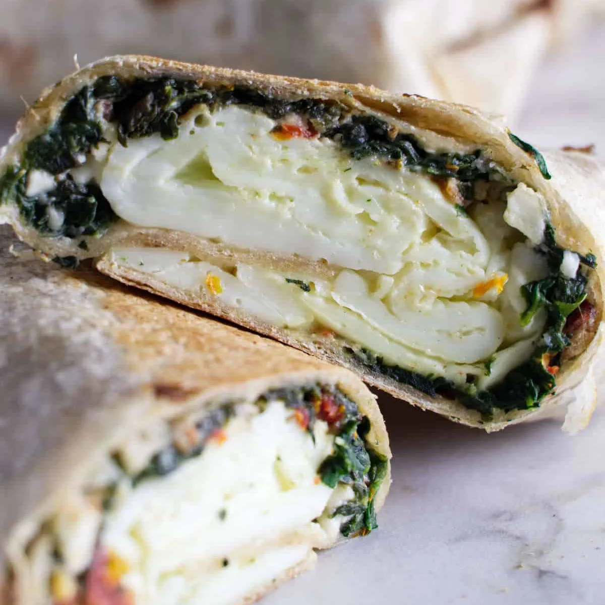 A spinach egg white wrap sliced in half.