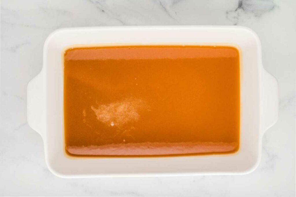 Pouring the caramel sauce into a baking pan.