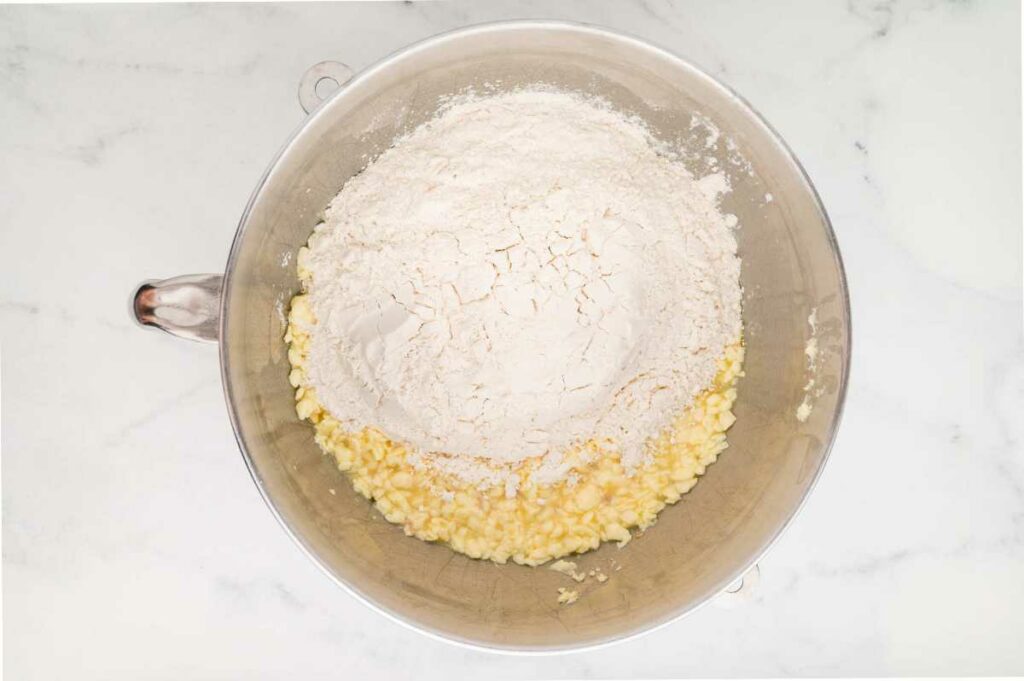 Adding the dry ingredients to the bowl to make the dough.