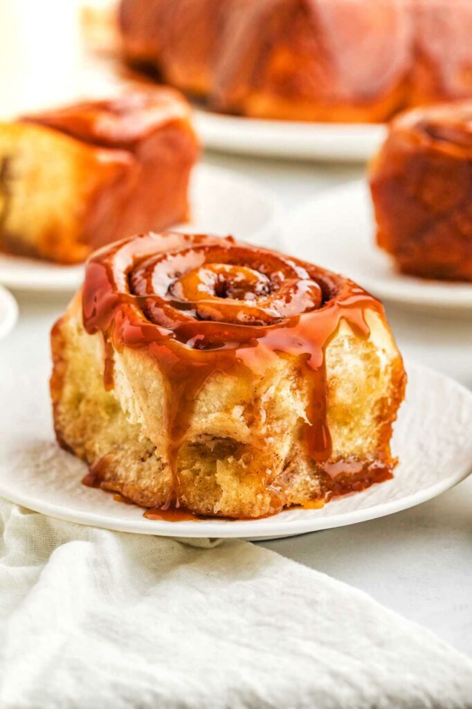 Sticky caramel cinnamon rolls on a plate.