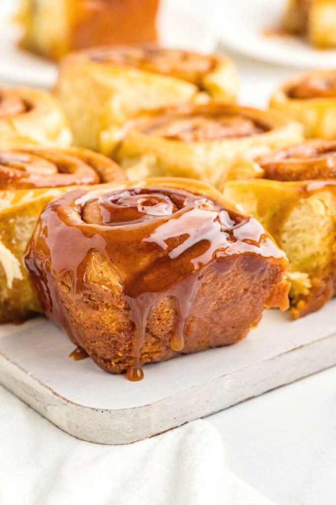 Warm cinnamon rolls with caramel sauce dripping down the edges.