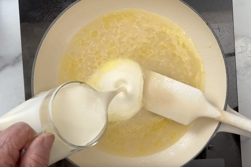 Pouring the cream into the skillet.