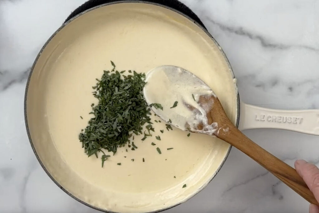 Adding tarragon to the cream reduction.