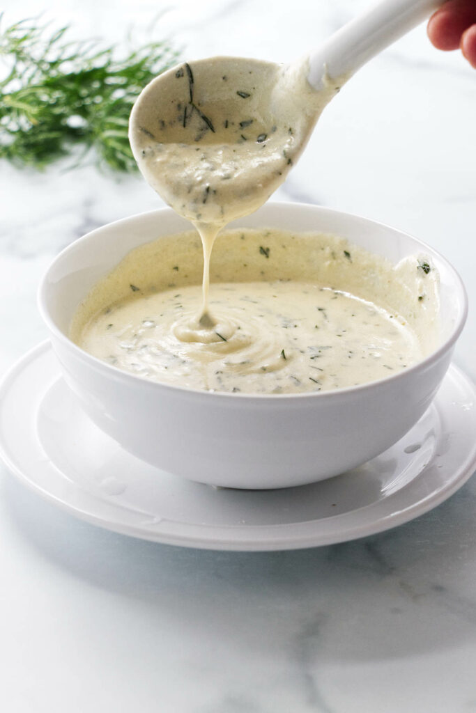 Pouring sauce into a bowl.