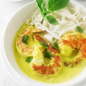 Curry prawns in a dish with rice noodles.