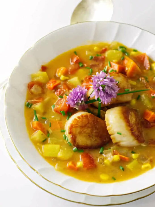 Vegetable and scallop chowder in a soup bowl.