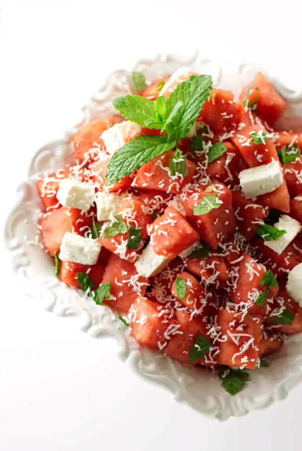 A dish filled with watermelon feta salad with mint.