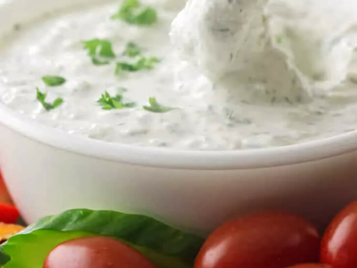 Dipping celery in a bowl of yogurt dip.