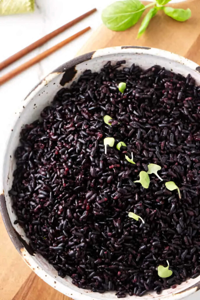 A bowl of black rice made in the instant pot garnished with basil.