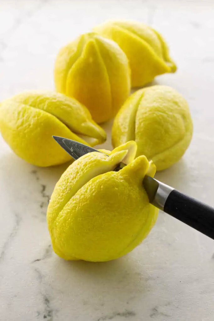 Slicing down the center of lemons prior to preserving them.