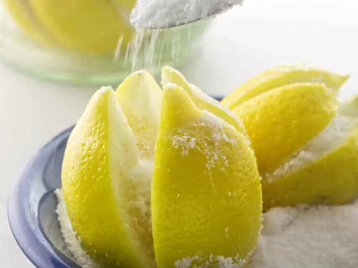 Pouring salt into sliced crevices of a lemon to make preserved lemons.