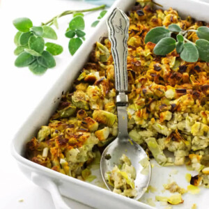 A white casserole dish filled with artichoke and leek stuffing.