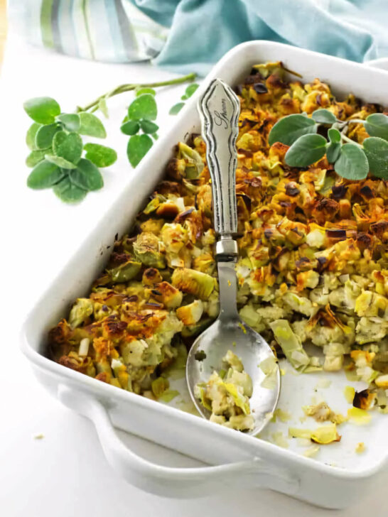 A white casserole dish filled with artichoke and leek stuffing.