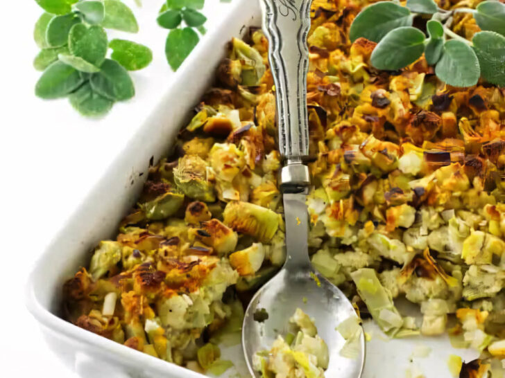 A white casserole dish filled with artichoke and leek stuffing.