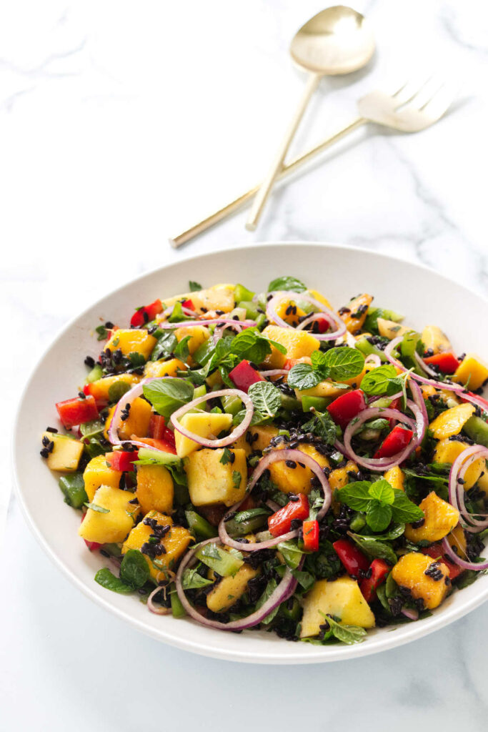 Mixing the mango salad with black rice and veggies.