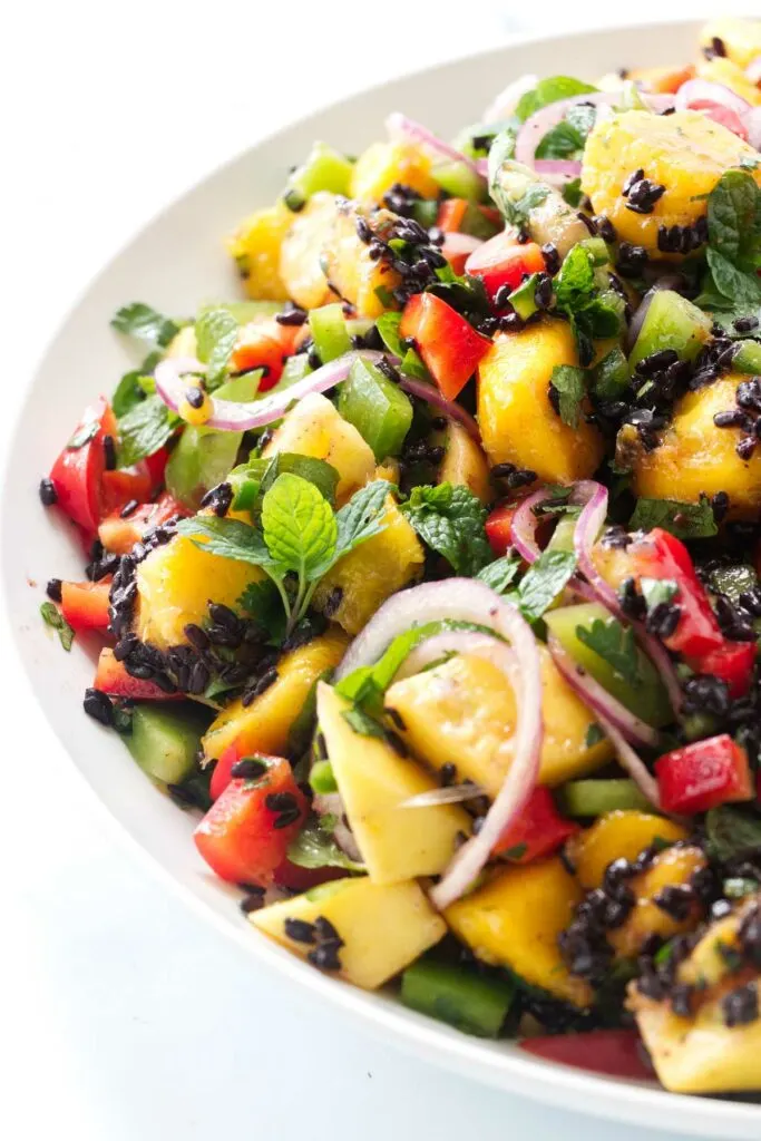 A black rice and mango salad in a large serving bowl.