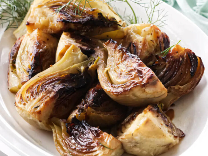 A serving dish with caramelized balsamic fennel next to a serving fork.